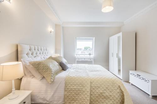 Habitación blanca con cama y ventana en Luxury 2 Bedroom Apartment in South kensington en Londres