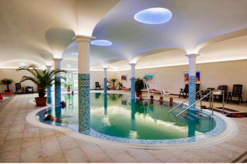 a swimming pool in a building with people in it at Aqua Faház in Mesteri
