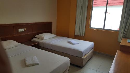 a hotel room with two beds and a window at Prime Hotel in Limbang