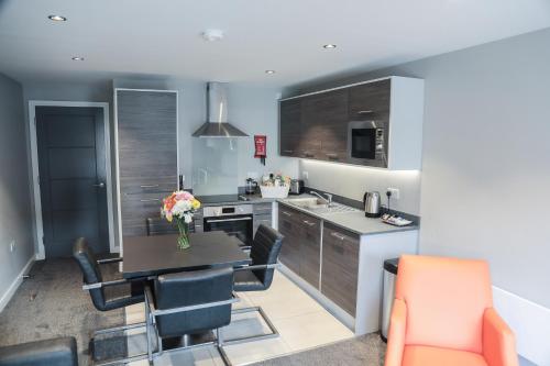 a kitchen with a table and chairs in a room at Dream Apartments St Thomas Hall in Belfast