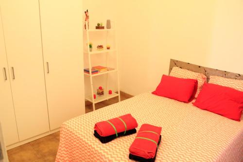 a bedroom with a bed with red pillows on it at Casa Colonial Vegueta in Las Palmas de Gran Canaria