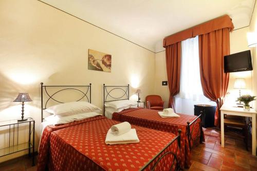 pokój hotelowy z 2 łóżkami i telewizorem w obiekcie B&B Relais Il Campanile we Florencji