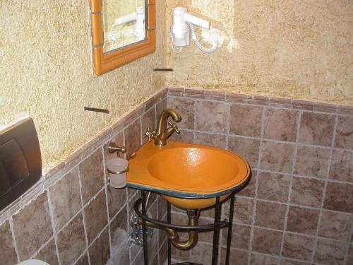 a bathroom with a copper sink in a tiled wall at Smaragdi Luxury Apartments in Skala Sotiros