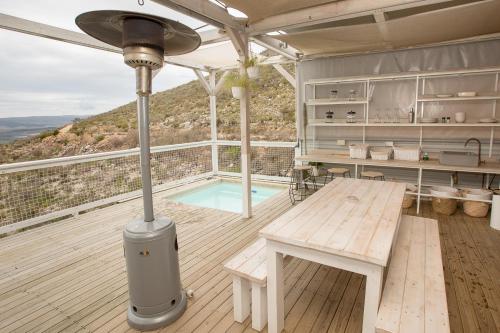 a deck with a bench and a table and a pool at Old Mac Daddy in Botrivier