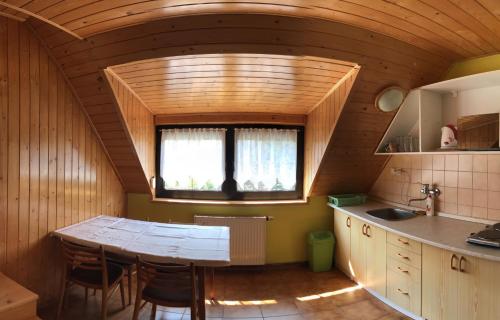 a kitchen with a table and a window in a room at Chalupa Podlesí in Podlesí