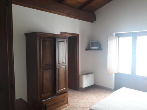 - une chambre avec un lit et une armoire en bois dans l'établissement Terrazze sul frido, à Viggianello