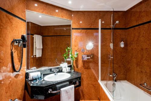 y baño con lavabo y ducha. en Hotel Madrid Plaza de España, Affiliated by Meliá, en Madrid