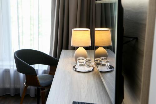 two lamps on a wooden table with two chairs at Hotel Antonio in Uzhhorod