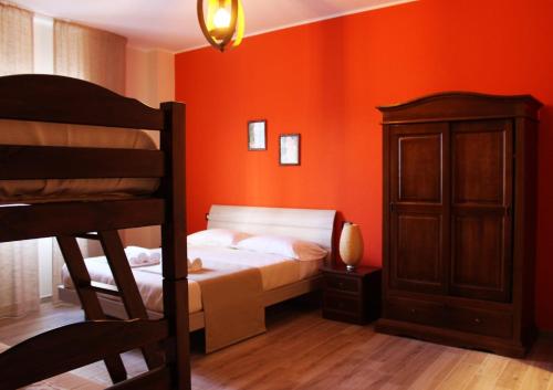 a bedroom with orange walls and a bed and a cabinet at Isolabella in Mazara del Vallo