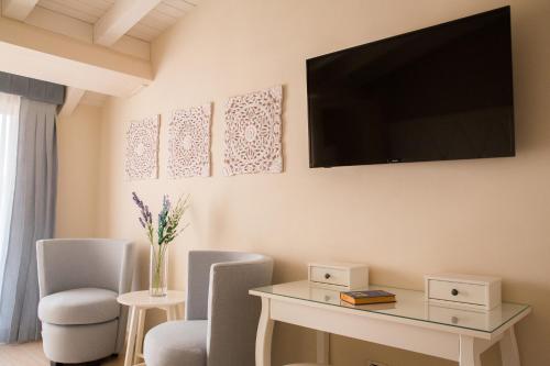 a living room with a table and a television on the wall at Attico in Canicattì