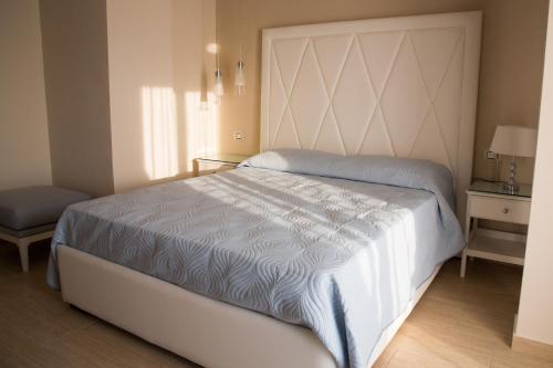 a bedroom with a large white bed and a chair at Attico in Canicattì