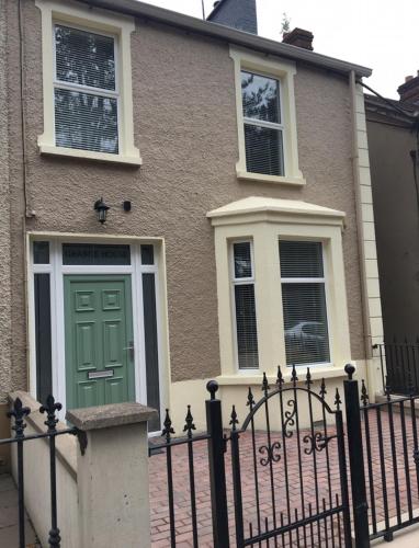 a house with a green door and a fence at Grange House in Omagh