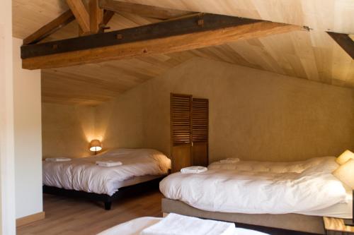 two beds in a room with a attic at Le Puy Carmin - Chambre d'hôtes avec jacuzzi in Bazoges-en-Paillers