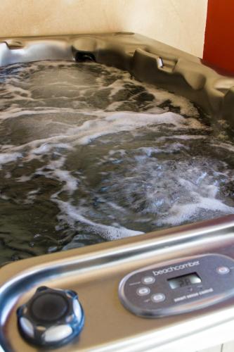 a hot tub with water in it with a remote control at Le Puy Carmin - Chambre d'hôtes avec jacuzzi in Bazoges-en-Paillers