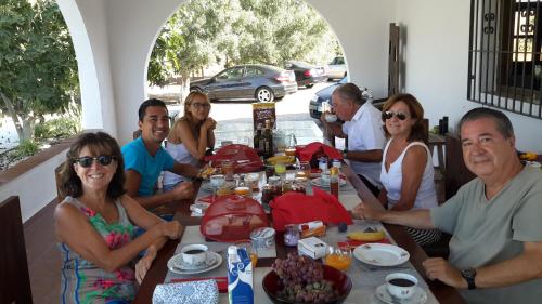een groep mensen die rond een tafel zitten bij Cortijo Oro Verde B&B in Tabernas
