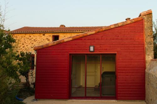 a red shed with a large glass door at Le Puy Carmin - Chambre d'hôtes avec jacuzzi in Bazoges-en-Paillers