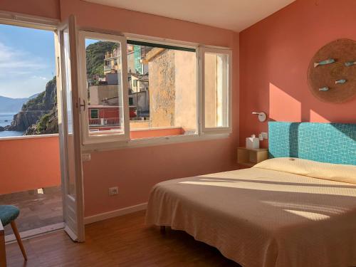 a bedroom with a bed with a view of the ocean at Ai Pesci Room Rental in Riomaggiore