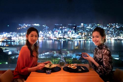 two women sitting at a table with plates of food at Garden Terrace Nagasaki Hotels & Resorts in Nagasaki