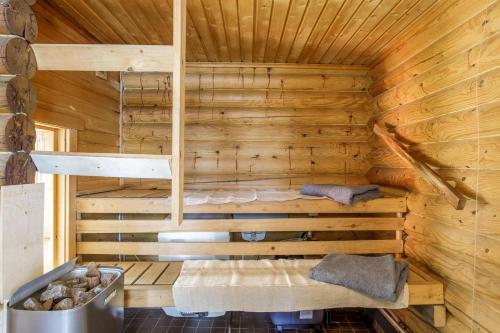 a log cabin with a bed in the corner at Säilöksen Lomahuvilat in Luhanka