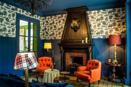 - un salon avec des chaises orange et une cheminée dans l'établissement Château de Picheny - B&B Esprit de France, à Picheny