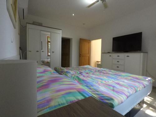 ein Schlafzimmer mit einem Bett mit einer bunten Decke in der Unterkunft Ferienwohnung auf dem Sturmhof in Grefrath