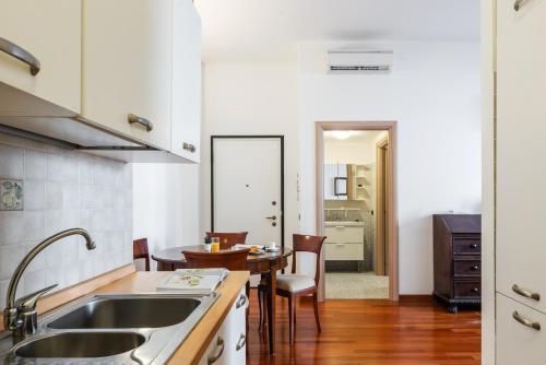 een keuken met een wastafel en een tafel bij Panzeri Flexyrent Apartment Aircon e WiFi in Milaan