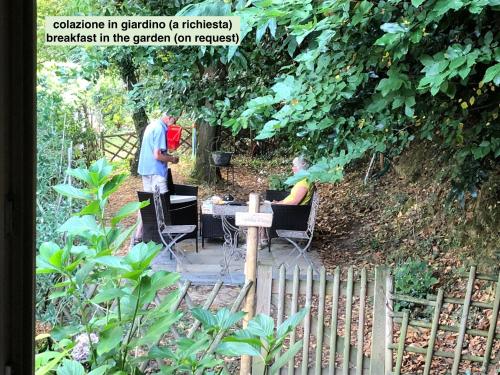 two people sitting at a table in a garden at Agula Relais camera matrimoniale in Pugnano