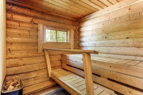 a sauna in a log cabin with a window at Säilöksen Lomahuvilat in Luhanka