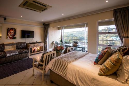 a bedroom with a large bed and a living room at 515 Umdloti Resort in Umdloti