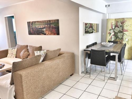 sala de estar con sofá y mesa en Renovated apt 100m from beach WiFi AC en Anavissos