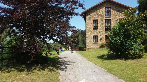 a stone building and a path in front of a building at Casa La Escuela in Tuilla