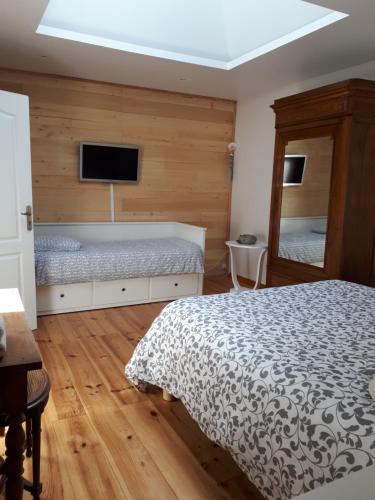 a bedroom with a bed and a tv on the wall at Le Relais de la Praya in Lège-Cap-Ferret