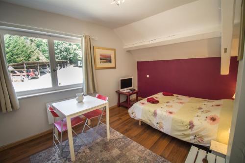 ル・ホーヴァルトにあるl'INTERMEDEのベッドルーム1室(ベッド1台、テーブル、窓付)