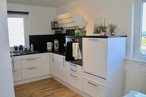a kitchen with white cabinets and a stove top oven at Nordic Inn Thorshavn in Tórshavn