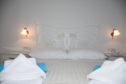 a bedroom with a large white bed with two pillows at Arion Bay Hotel Santorini in Kamari