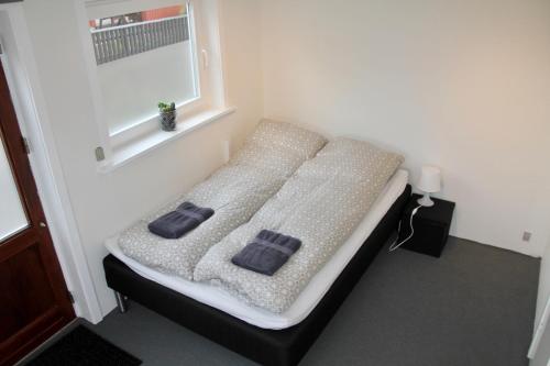 a bed in a room with two pillows on it at Nordic Inn Thorshavn in Tórshavn