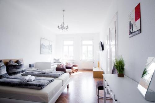 een witte woonkamer met 2 bedden en een bank bij Auwald Apartment in Leipzig