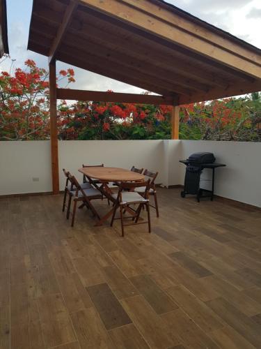 a patio with a table and chairs and a grill at KSL Residence in Boca Chica