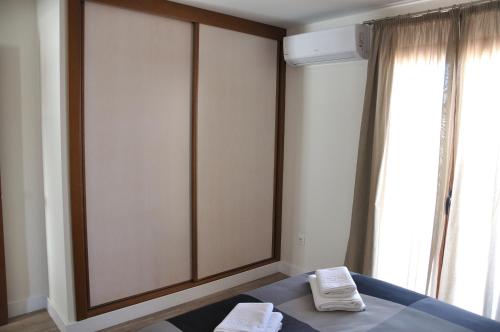 a bedroom with a bed with two white towels on it at Apartamentos Sábora in Ronda