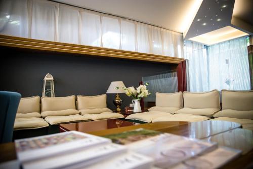 a living room with white couches and a table at Wyndham Garden Conegliano in Conegliano