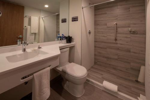 a bathroom with a toilet and a sink and a shower at Microtel Inn & Suites by Wyndham San Luis Potosi in San Luis Potosí