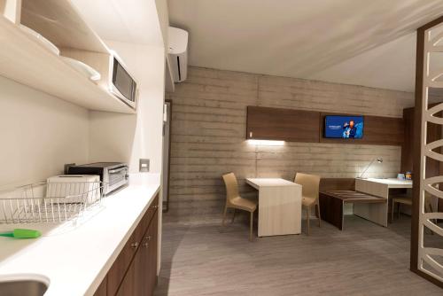 - une cuisine et une salle à manger avec une table et des chaises dans l'établissement Microtel Inn & Suites by Wyndham San Luis Potosi, à San Luis Potosí