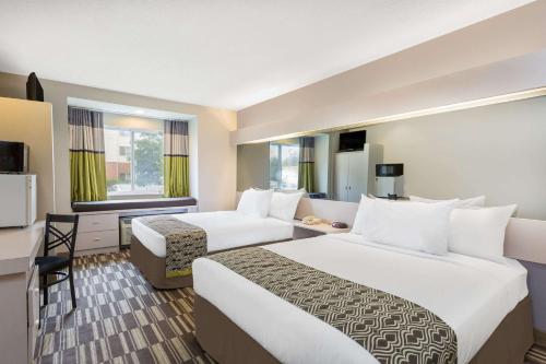 a hotel room with two beds and a television at Microtel Inn & Suites by Wyndham in Sandston
