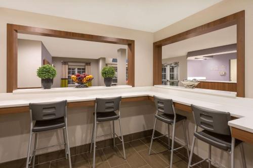 a bar with stools in a room with a mirror at Microtel Inn & Suites by Wyndham in Sandston