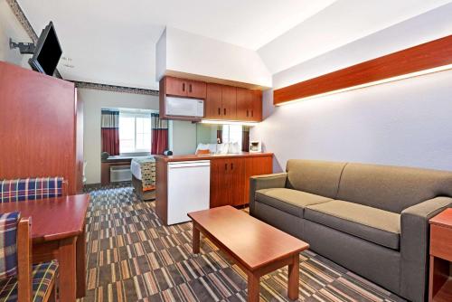 a living room with a couch and a kitchen at Microtel Inn & Suites Urbandale in Urbandale