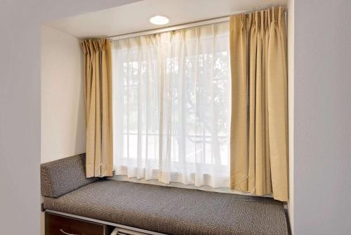 a window in a room with a curtain at Microtel Inn and Suites by Wyndham - Geneva in Geneva
