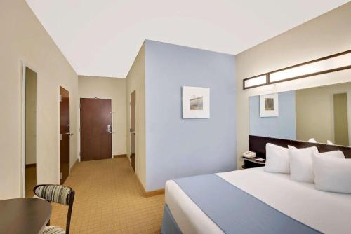 a large hotel room with a bed and a table at Microtel Inn and Suites by Wyndham - Geneva in Geneva