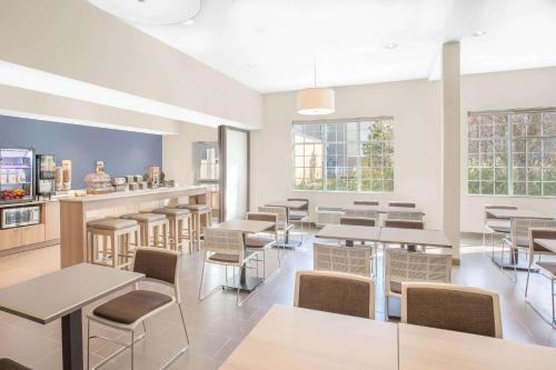 a restaurant with tables and chairs and windows at Microtel Inn & Suites by Wyndham Ocean City in Ocean City