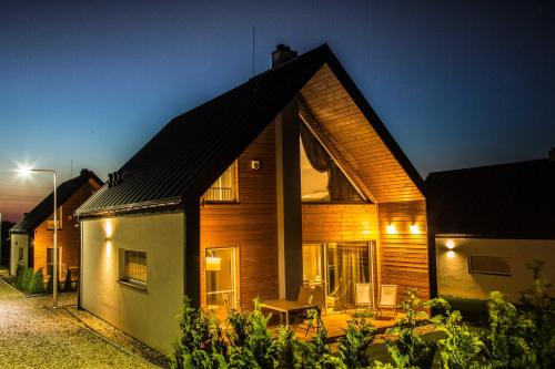 a wooden house with a porch at night at Jaśminowy Sad in Mikołajki