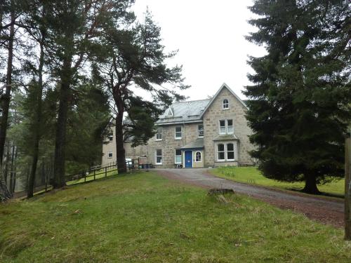 a large stone house with a driveway at Braemar Youth Hostel in Braemar